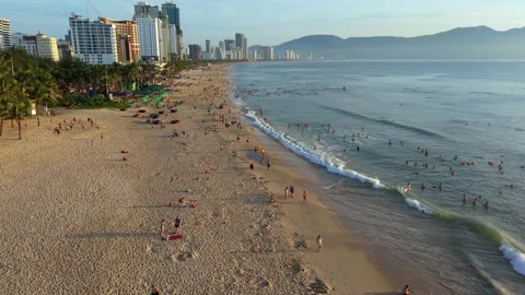 Aerial drone flight along Da Nang beach with morning waves and skyline Vídeo Stock 340536467