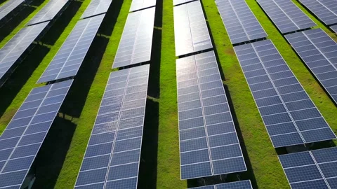 Aerial drone flight along the rows of solar power plant at sunset in the green Stock Footage 236148993