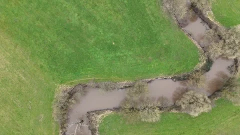 Aerial Drone Flight Along a Winding River Through Rural Farmland Stock Footage 328935272