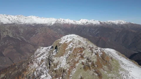 Aerial drone flight approaching the top of the snowy mountain in autumn Stock Footage 215875473