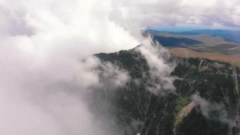 Aerial drone flight in Bucegi mountains, Romania, with clouds covering the scene Stock Footage 130852842