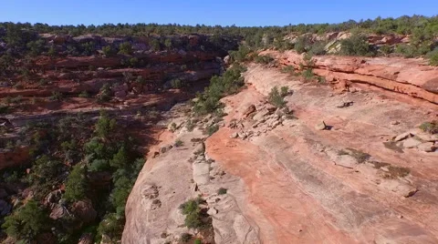 Aerial drone of flight dropping into red cliff desert canyon to reveal hiker Stock Footage 60405638