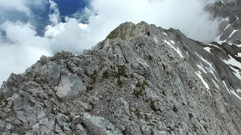 Aerial drone flight of hiker walking offer rock pass in the austrian alps Stock Footage 80570341