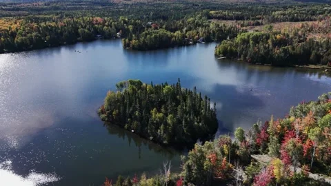 Aerial drone flight over a calm lake reflecting the blue sky Stock Footage 346564343