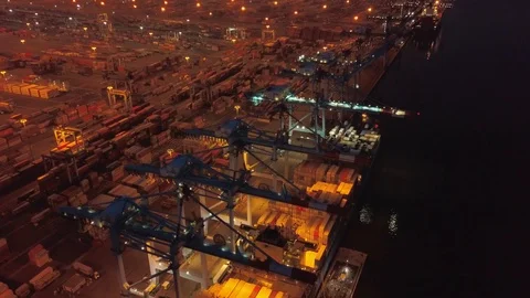 Aerial drone. Flight over container port with ships and cranes at Night Stock Footage
