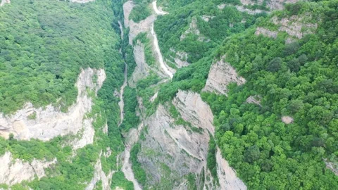 Aerial drone flight over a deep dramatic mountain gorge Vídeos de archivo 338014775