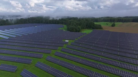 Aerial drone flight over extensive solar farm with dramatic clouds and mist Stock Footage 345691907