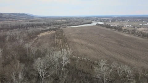 Aerial drone flight over forest and farmland towards a winding river Stock Footage 337394643