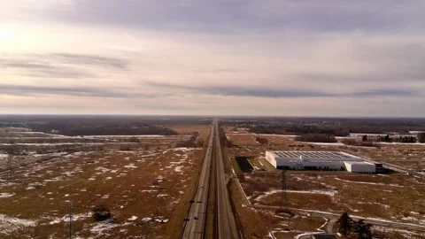 Aerial drone flight over highway with logistics warehouse in winter landscape Stock Footage 331070354