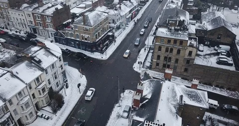 Aerial drone flight over an intersection in London, England during a snowstorm. Видео 87168687