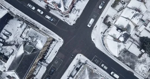 Aerial drone flight over an intersection in London, England during a snowstorm. Видео 87168706
