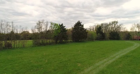 Aerial drone flight over large field and fence line Stock Footage 107061671