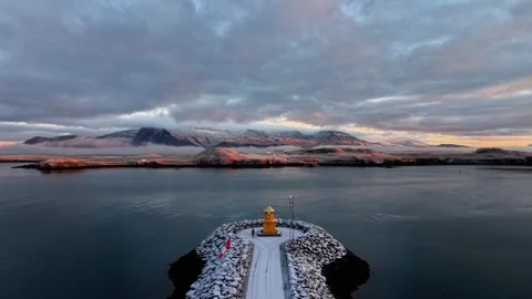 Aerial drone flight over lighthouse and rocky Icelandic coast at sunrise Video stock 326132208