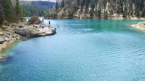 Aerial drone flight over mountain lake surround by fir trees and rocks with Video stock 80540076