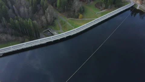 Aerial drone flight over mountain lake water with a top-down view of the dam str Stock Footage 321246862
