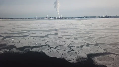Aerial drone flight over a partially frozen lake with smoke pillar Stock Footage 103831060