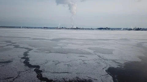 Aerial drone flight over a partially frozen lake with smoke pillar Stock Footage 103832027