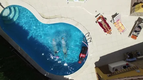 Aerial drone flight over pool with girls jumping into the water on holidays Video stock 91016907