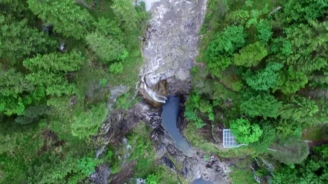 Aerial drone flight over river in valley with waterfall surrounded by green tree Video stock 80573787