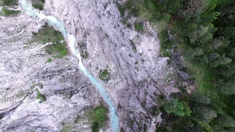 Aerial drone flight over river in a valley with rocks between green fir tree Video stock 80578895