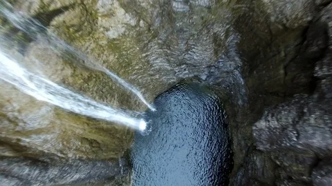 Aerial drone flight over river in valley with waterfall surrounded by green tree 스톡 동영상 80648230