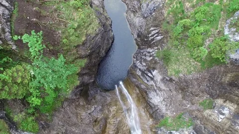 Aerial drone flight over river in valley with waterfall surrounded by green tree 스톡 동영상 80648296