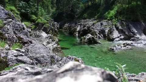 Aerial drone flight over river in a valley with rocks between green fir tree Video stock 95228835