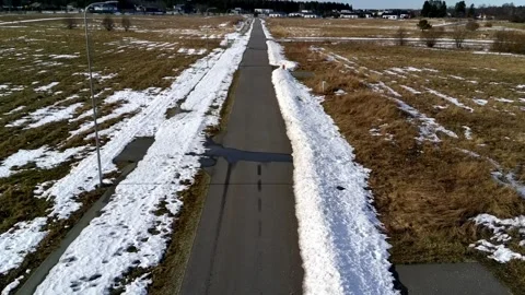 Aerial drone flight over rural road through snowy countryside in winter Stock Footage 331070345