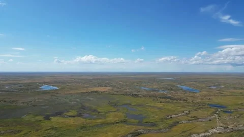 Aerial drone flight over the vast Kazakh steppe with a winding dirt road Stock Footage 341422368