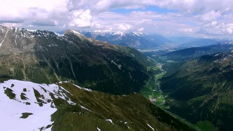 Aerial drone flight from summit over small valley between high mountans with Video stock 80553590