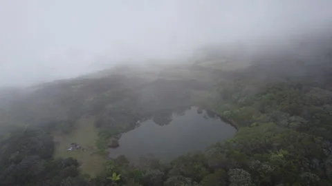 Aerial drone flight through clouds over volcanic crater lake Reunion Island Stock Footage 317878552