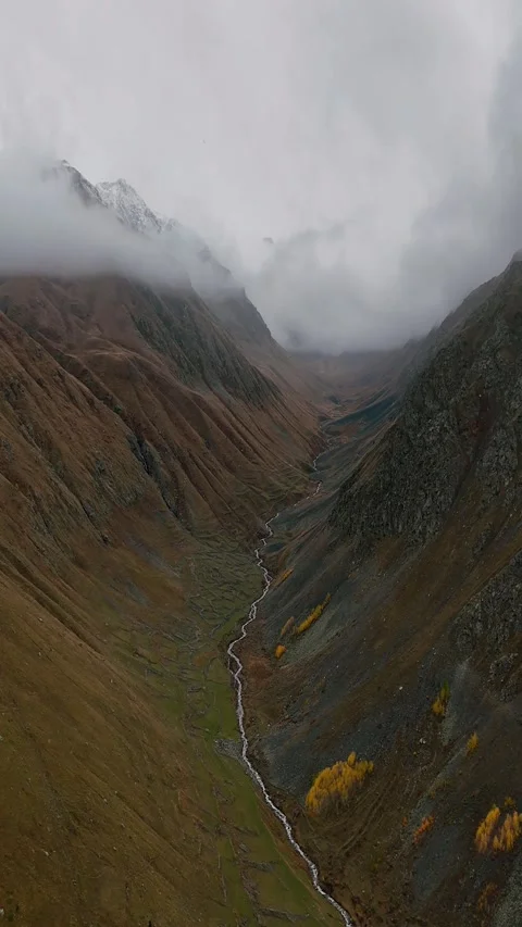 “Aerial Drone Flight Through a Narrow Foggy Valley with Light Snowfall – Autumn  Stock Footage 323127903