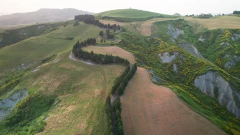 Aerial drone flight through Volterra Tuscany countryside with countryroad Stock Footage 311324026