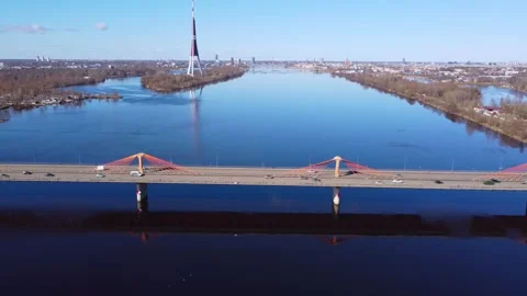 Aerial drone flight toward a cable-stayed bridge over a calm river with a Stock Footage 304858698
