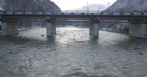 Aerial drone flight under the bridge near water, beautiful landscape and snow Stock Footage 125460751