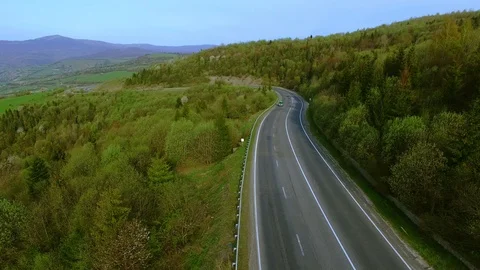 Aerial drone flight view over the highway surrounded with mountains and woods 스톡 동영상 105272790