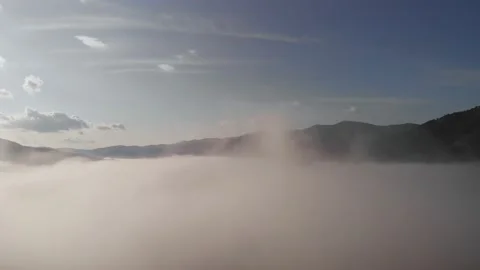 Aerial drone flight view over low clouds and morning mist covered mountain Stock Footage 158896841
