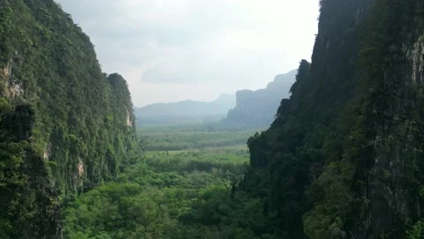 Aerial drone fly between mountains over pristine green jungle, cinematic video Stock Footage 235408318