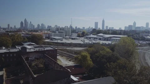 Aerial Drone Fly over decrepit building sharp tilt up to Atlanta City Skyline Stock Footage 82449996