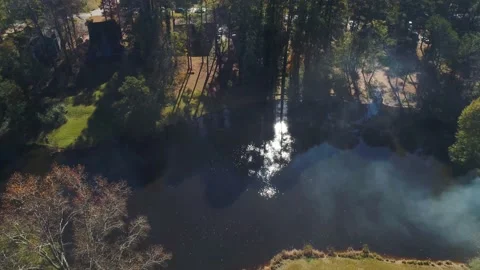 Aerial drone fly over of small lake with a glimpse of sun. Stock Footage 170458415