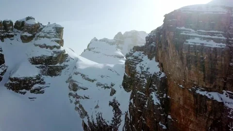 Aerial drone flying closely between snowy rock formations Stock Footage 219431701