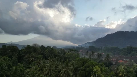 Aerial Drone Flying Forward Over Traditional Village in Bali and Sacred Mountain Stock Footage 332463022