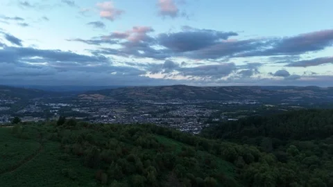Aerial Drone Flying Forward Over Forest and Town at Sunset, Wales Stock Footage 343578245