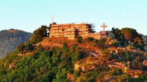 Aerial: drone flying at old medieval abbey perched on mountain top, at sunrise.  Stock Footage 256826751