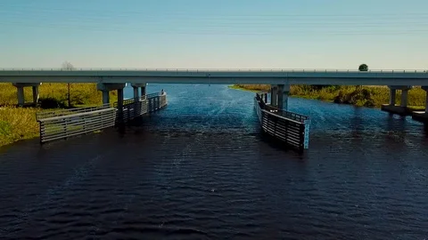 Aerial Drone Flying over a River and Under a Bridge Stock Footage
