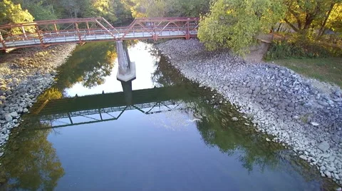 Aerial drone flying over a small river and over a bridge Stock Footage 68547372