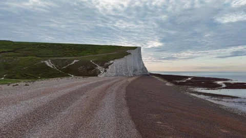 Aerial drone flyover along remote white cliffs and calm ocean beac Stock Footage 309763875