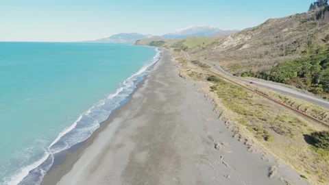 Aerial Drone Flyover of a Black Sand Beach with Mountains, New Zealand Stock Footage 337872765