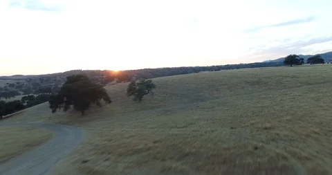 AERIAL DRONE FLYOVER FIELDS AND COUNTRYSIDE WITH SUNSET Stock Footage 127296906