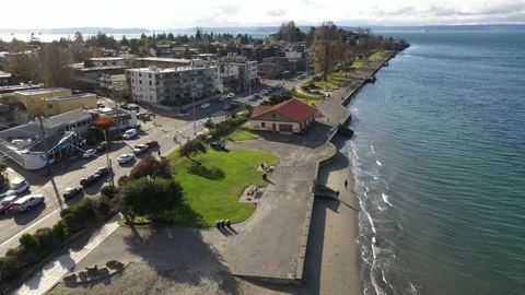 Aerial / drone footage of Alki Beach Park, sandy shoreline with a bike / Stock Footage 143942653